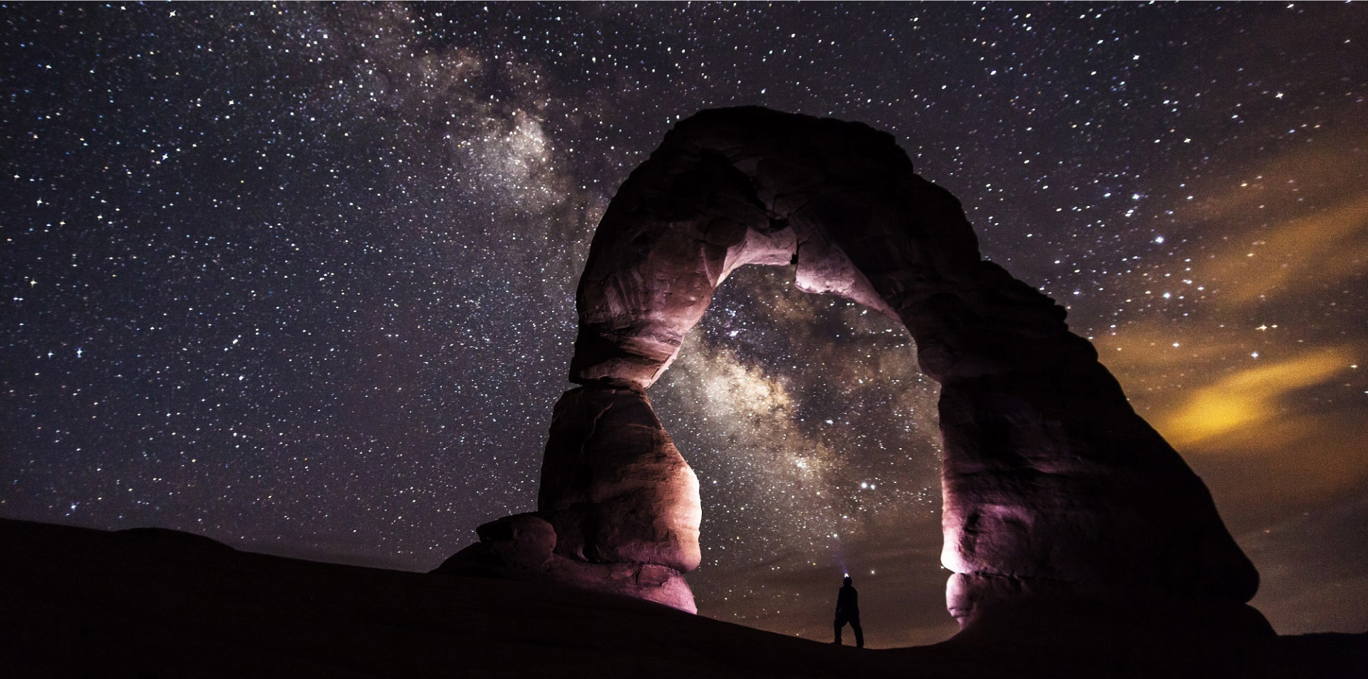 Night time shot of Delicate Arch in Arches National Park, showing the stars and Milky Way