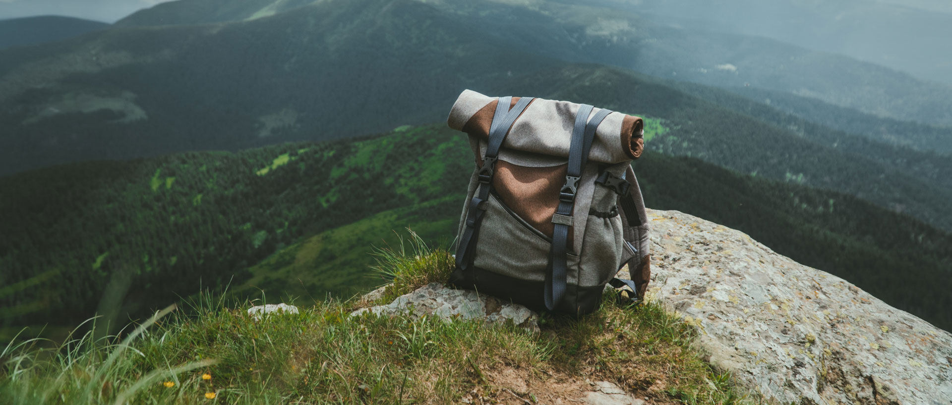 Backpack on ground with mountains in the distance